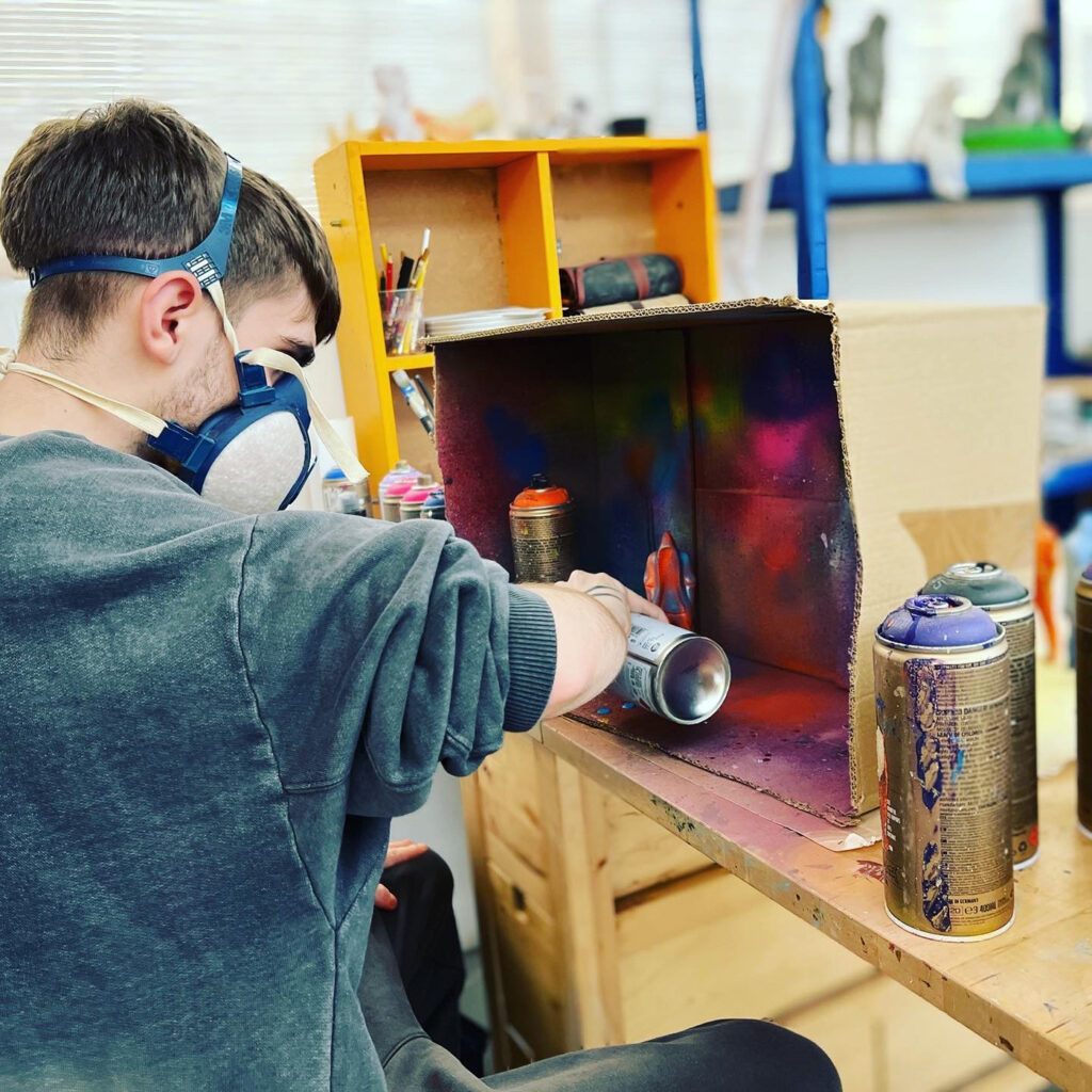 Young person making painting a sculpture